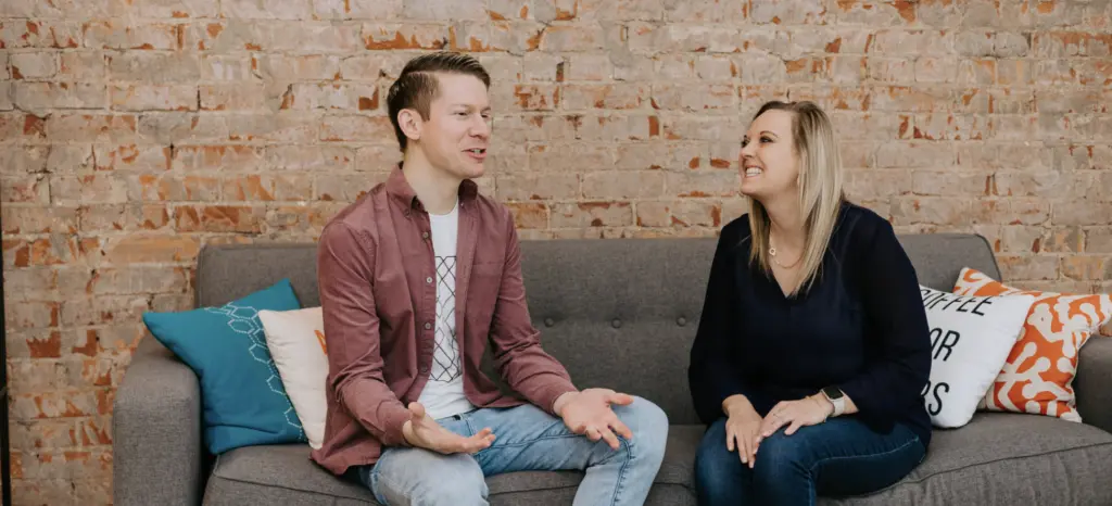 An image of two employees engaging a career conversation on a couch in an office. 